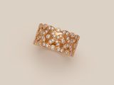a gold ring with white diamonds on a beige background