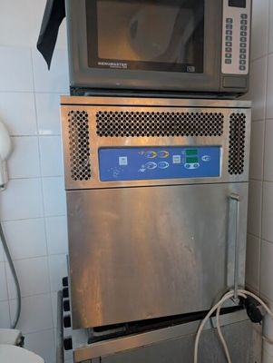 une photo d'une cuisine avec un micro-ondes et une poubelle