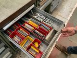 un homme en train d'ouvrir un tiroir contenant des outils