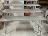 une table en métal sur laquelle se trouvent plusieurs étagères