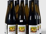 six bouteilles de vin sont alignées sur une surface blanche