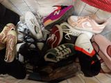 many pairs of shoes that are piled together on a bed