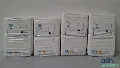 six paquets de couches pour bébés alignés en rang sur une table