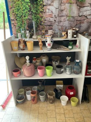 de nombreux pots et vases posés sur une étagère dans une pièce