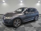 un SUV Audi gris garé dans un garage au sol carrelé