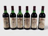 six bouteilles de vin sont alignées sur une surface blanche
