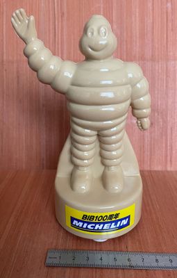 une figurine représentant un homme, posée sur une table avec une règle