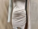 un mannequin vêtu d'une robe argentée recouverte d'une cape
