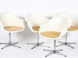 three white chairs sitting on top of each other in front of a white wall