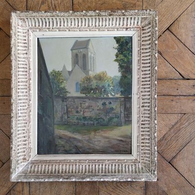 painting of a church in a white frame on a wooden floor