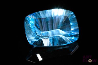 an image of a blue topazte stone on a black surface