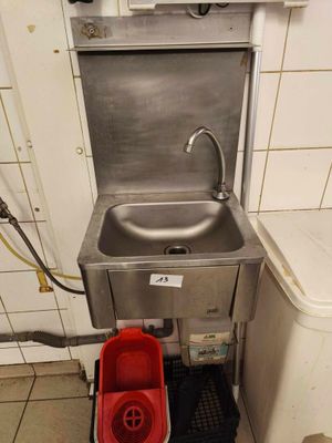 a sink and a bucket in a small room