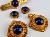 une photo d'un ensemble de bijoux dorés et bleus posé sur une surface blanche