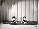 une paire de baskets noires et blanches posées sur un skateboard noir
