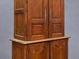 une vieille armoire en bois à deux portes et une étagère
