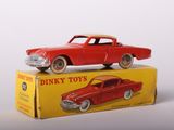 a red toy car sitting on top of a yellow box