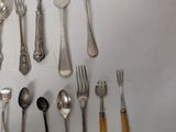 a lot of spoons and forks that are on the table