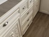 a kitchen with white cabinets and wood floors in it