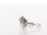 a close up of a diamond ring on a white surface
