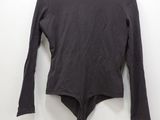 a black shirt hanging on a hanger on a white wall