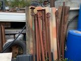 un tas de tuyaux et un tonneau bleu dans la cour