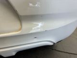 a close up of a car ' s front bumper with a denting on it