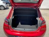 the back of a red car with its trunk open in a parking lot