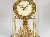 a gold clock under a glass dome on a table