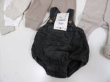 two pairs of overalls and a sweater on a table
