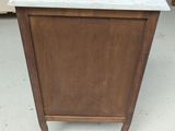 a small marble top cabinet in the middle of a room