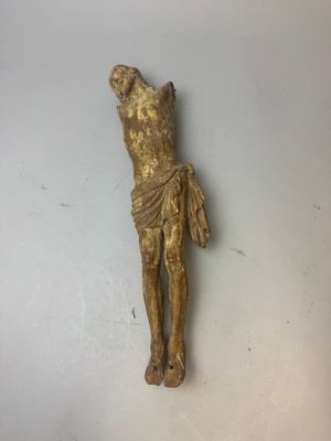 statue représentant un homme sur une croix, posée sur une surface blanche