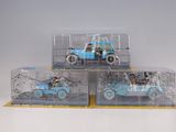 three toy cars in a clear box on a white surface