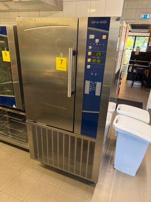 un grand réfrigérateur en acier inoxydable au milieu d'un magasin