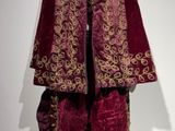 une photo d'une veste et d'un pantalon rouges et dorés sur un mannequin