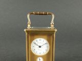 une image représentant une horloge dorée munie d'une manivelle, sur fond gris