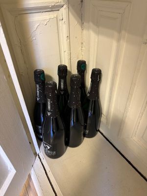 Plusieurs bouteilles de vin sont alignées sur une étagère dans une pièce