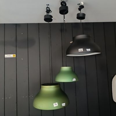 trois lampes vertes suspendues au plafond dans une pièce
