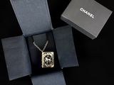 chanel necklace in a gift box with a chain on a black background