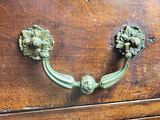 a green handle on a wooden drawer with flowers on it