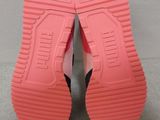 the soles of a pair of pink shoes on a gray surface