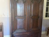 a large wooden armoire in the corner of a room
