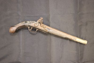 un vieux pistolet exposé sur un tissu noir