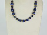 a necklace with blue glass beads on a white mannequin