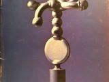 an old photo of a sculpture of a man on a ball