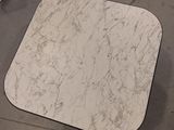 a white table with a marble top sitting on the floor