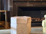 a chair and ottoman in front of a fireplace in a living room