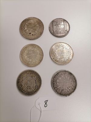 six different types of coins are displayed on a white surface