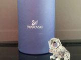 une figurine en cristal posée sur une table à côté d'une boîte bleue
