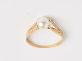 une bague en or avec une perle au centre