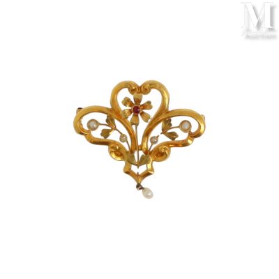 un gros plan d'une broche en or sertie d'une perle